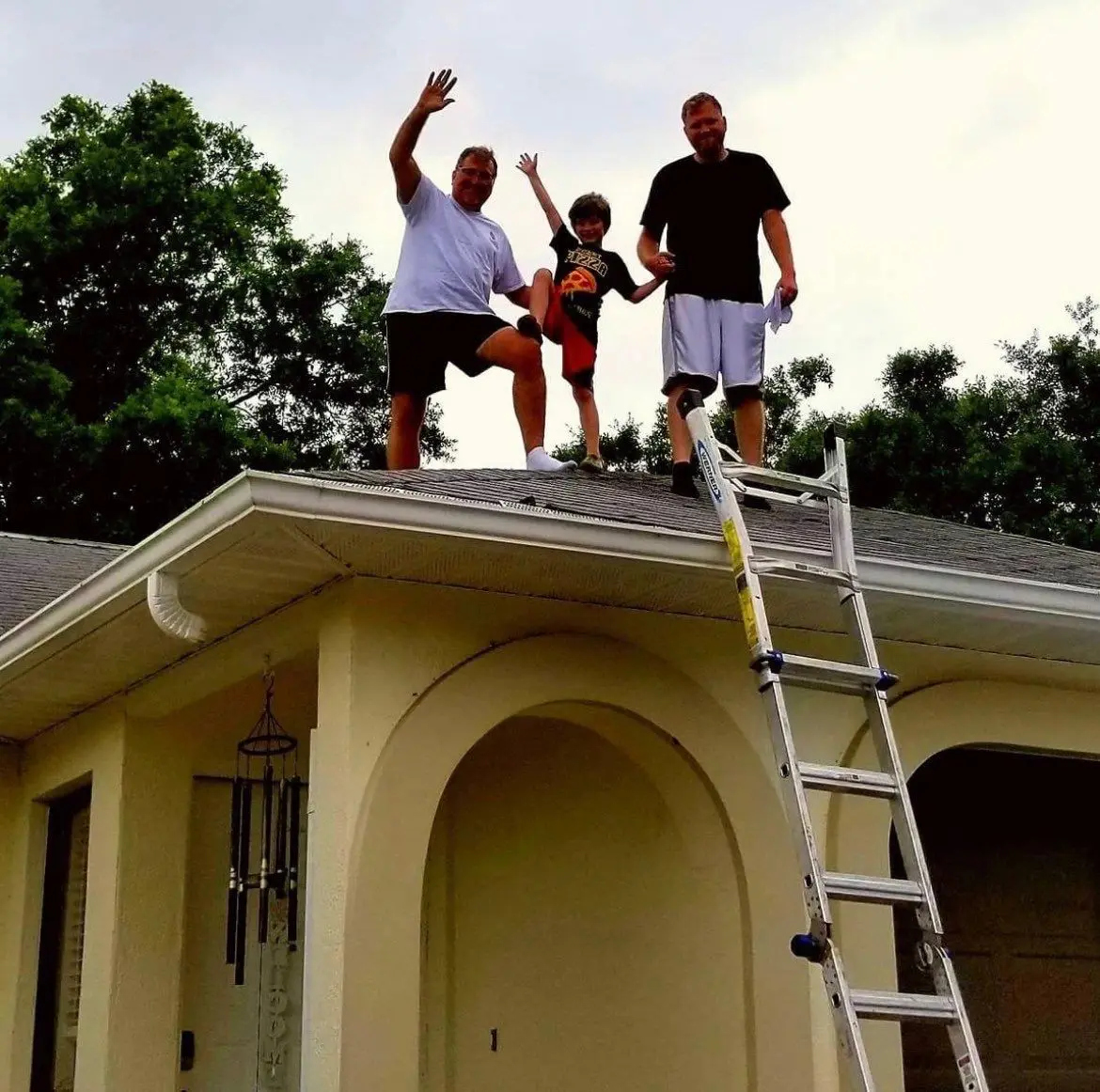 A group of people standing at the roof of a house